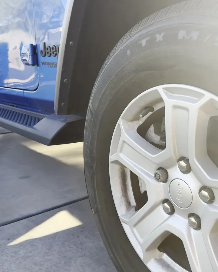 Jeep Wrangler wheel and tire covered in dust before detailing